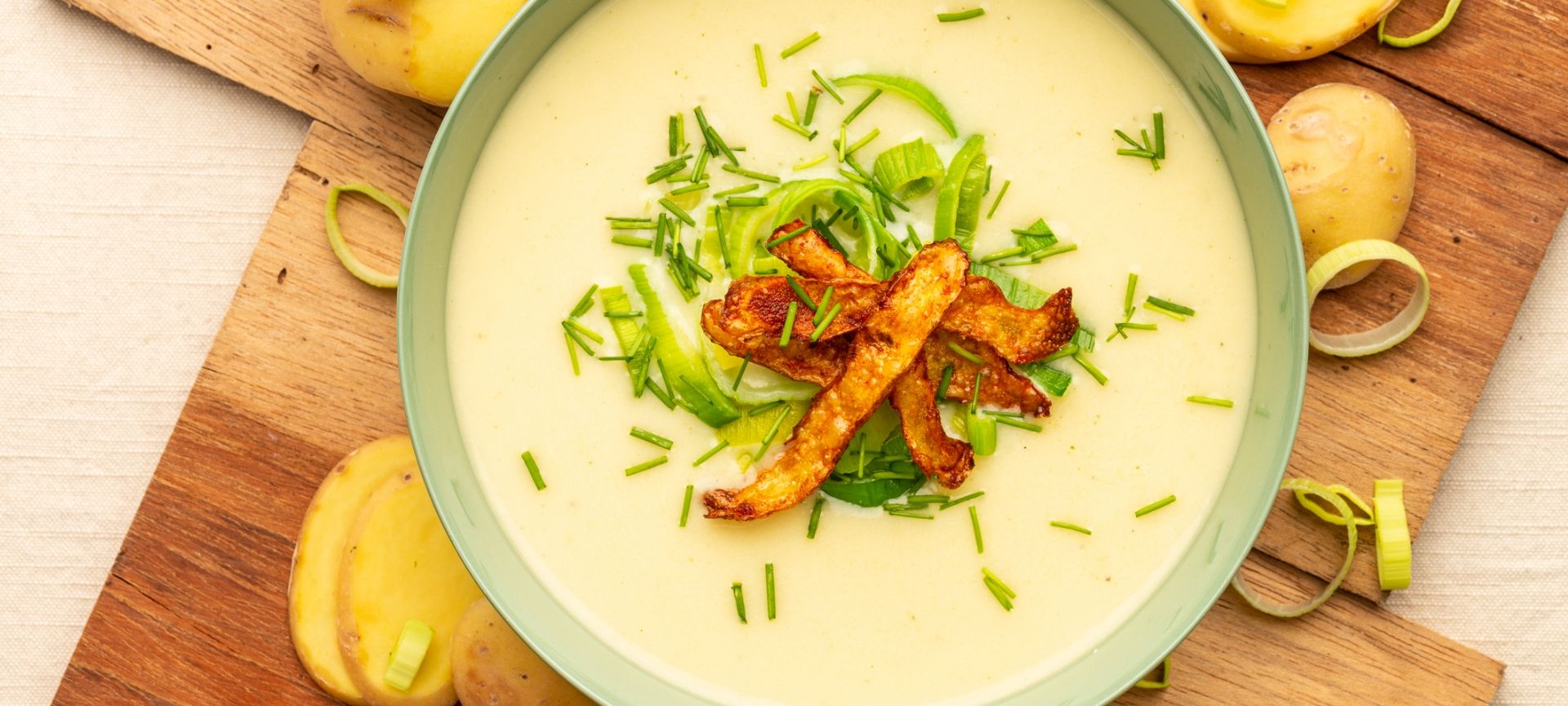 Kartoffelsuppe toppet med smørstegt porretop og sprødekartoffelskræller