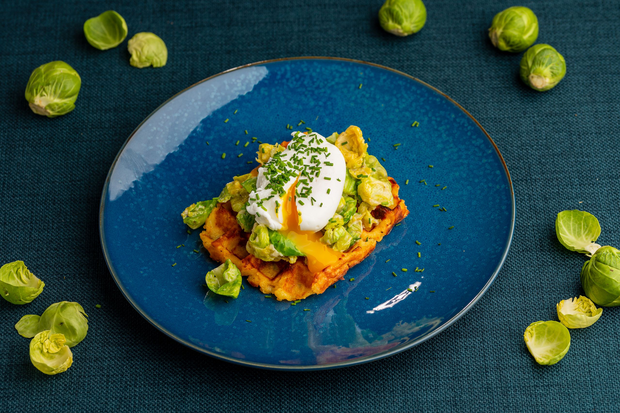 Kartoffelvarfel med blade af rosenkål og med et pocheret æg