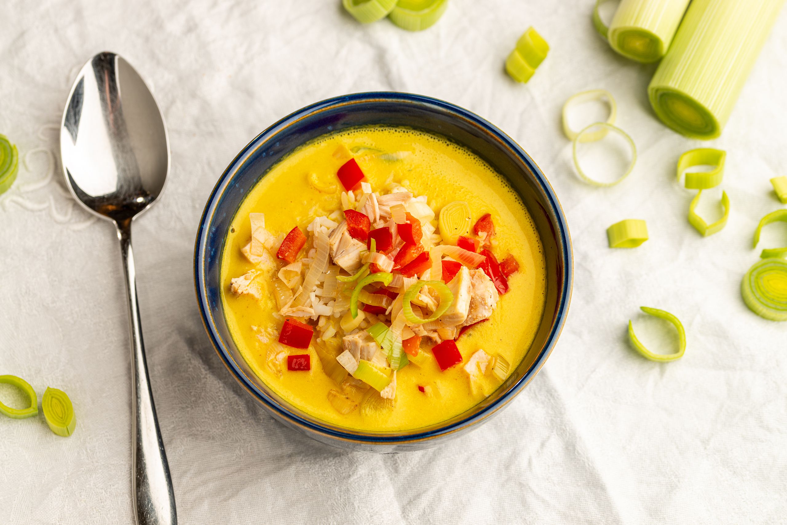 Karrysuppe med kylling. Supper er serveret med ris, sauterede porrering og rødbederfrugt