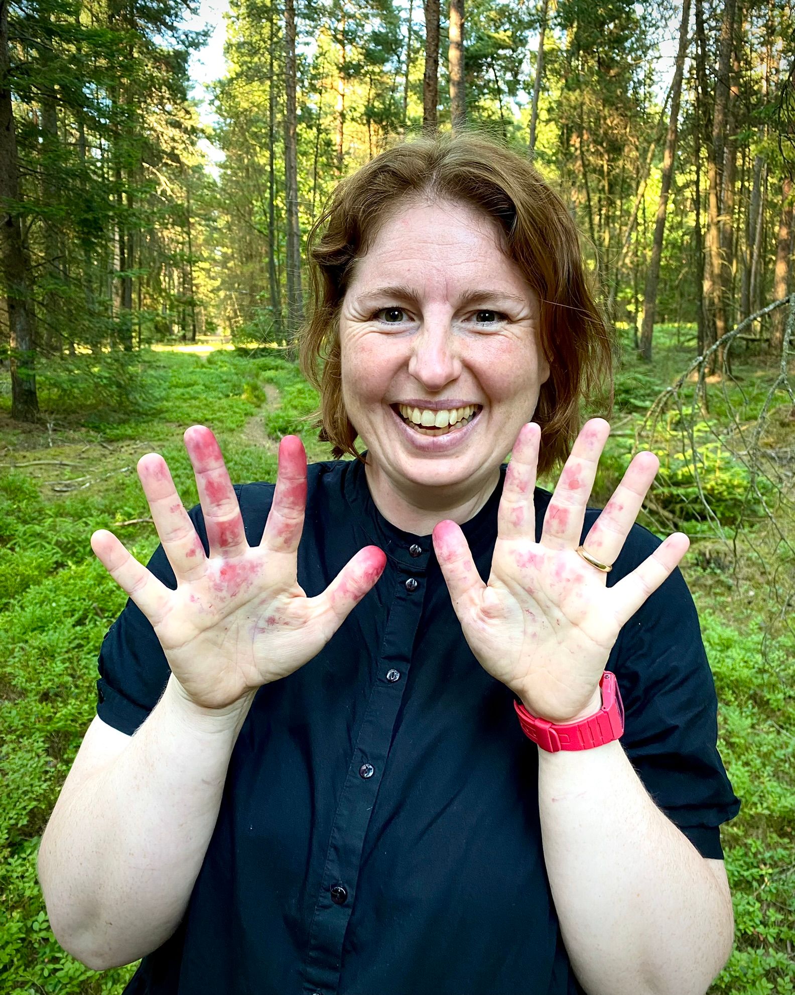 Signe viser sine fingre frem hvor man kan se blåbærsaften på fingerene.